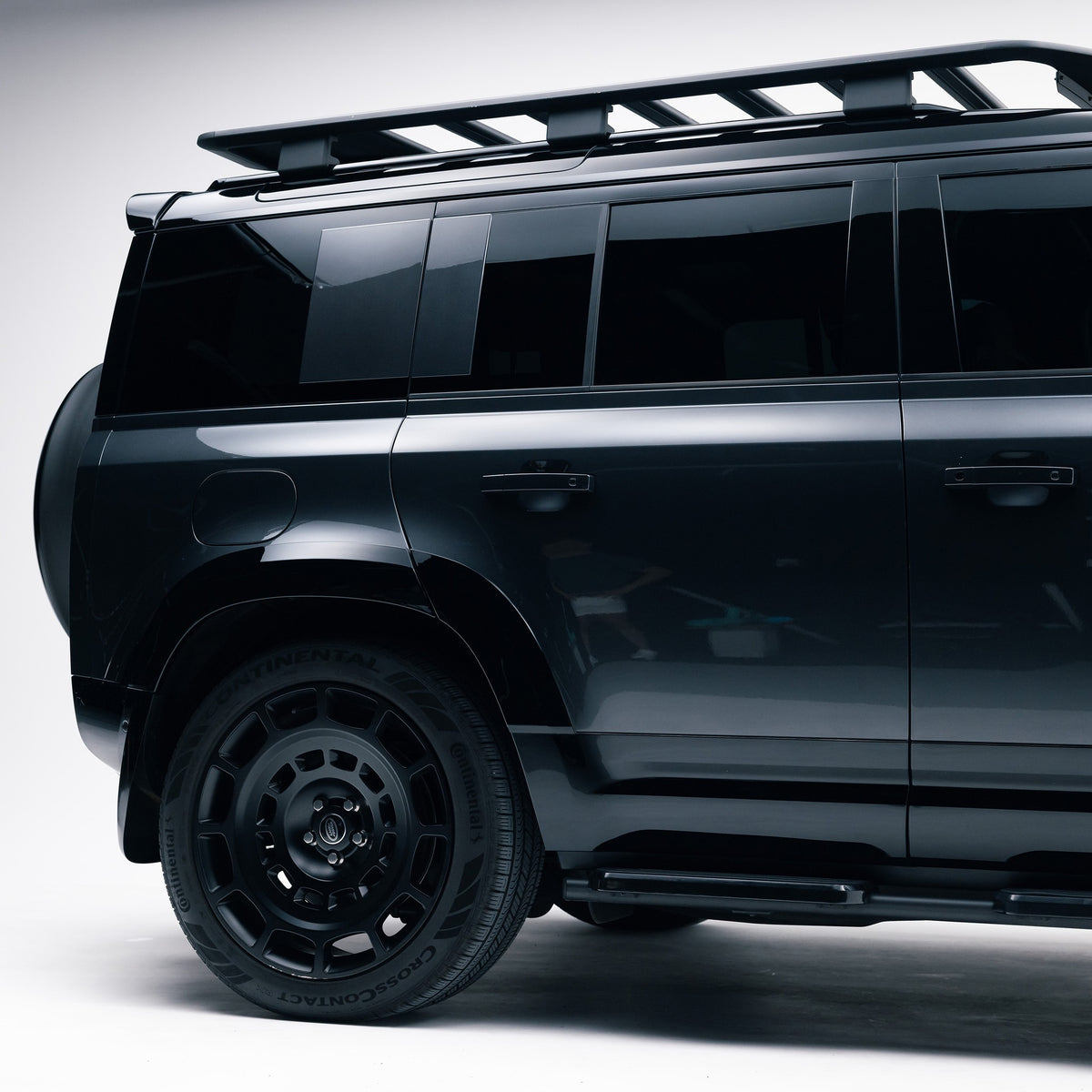 Land Rover Defender 110 rear side view showing Gloss Black door mouldings