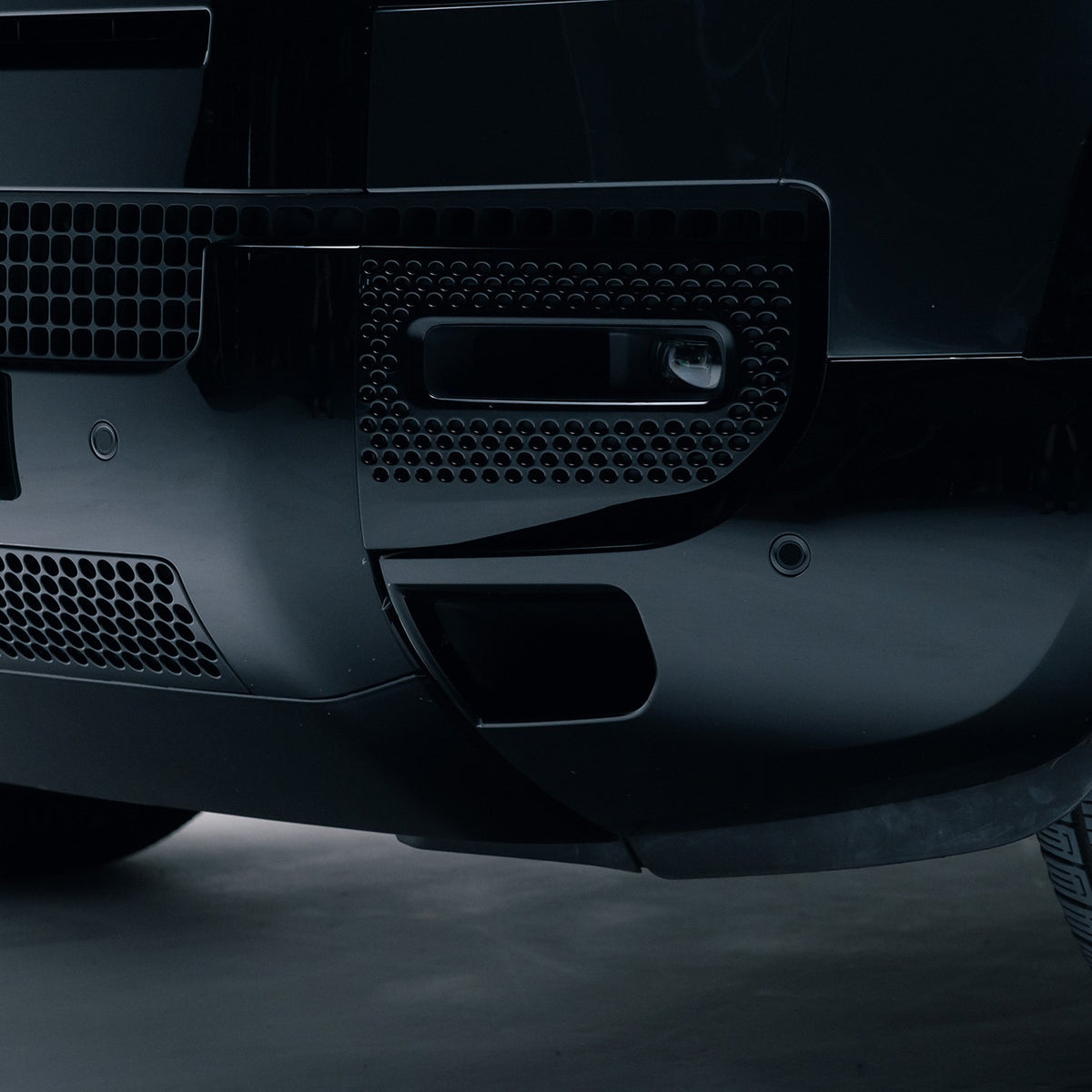 Gloss Black front bumper corner trim fitted to a Land Rover Defender 110