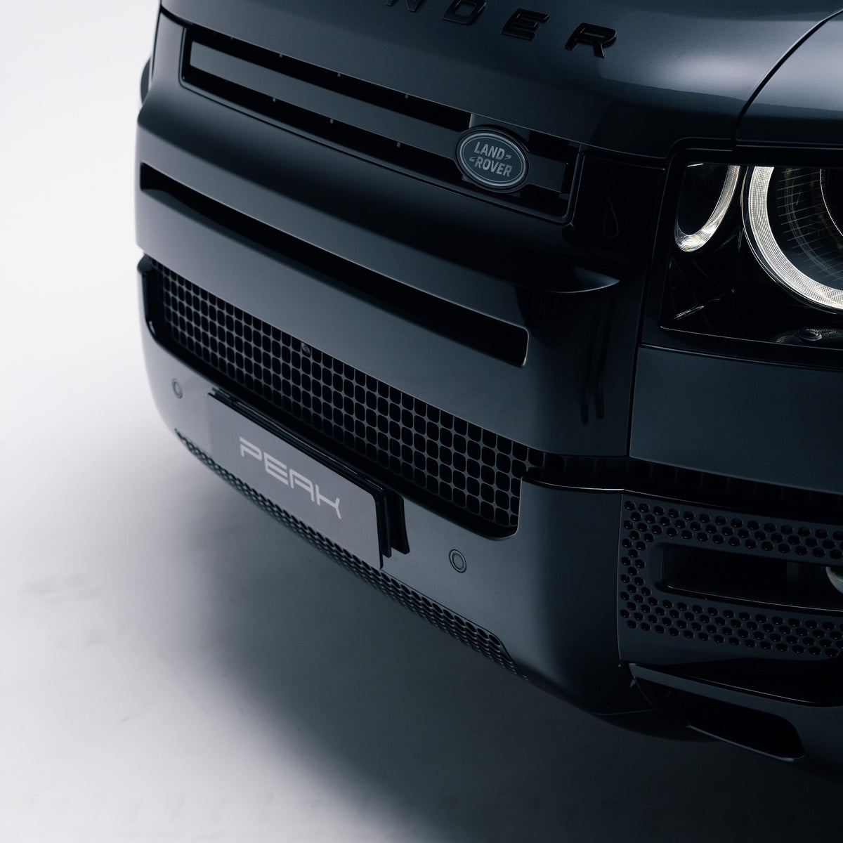 Gloss Black front grille trim and bumper on a Land Rover Defender 110