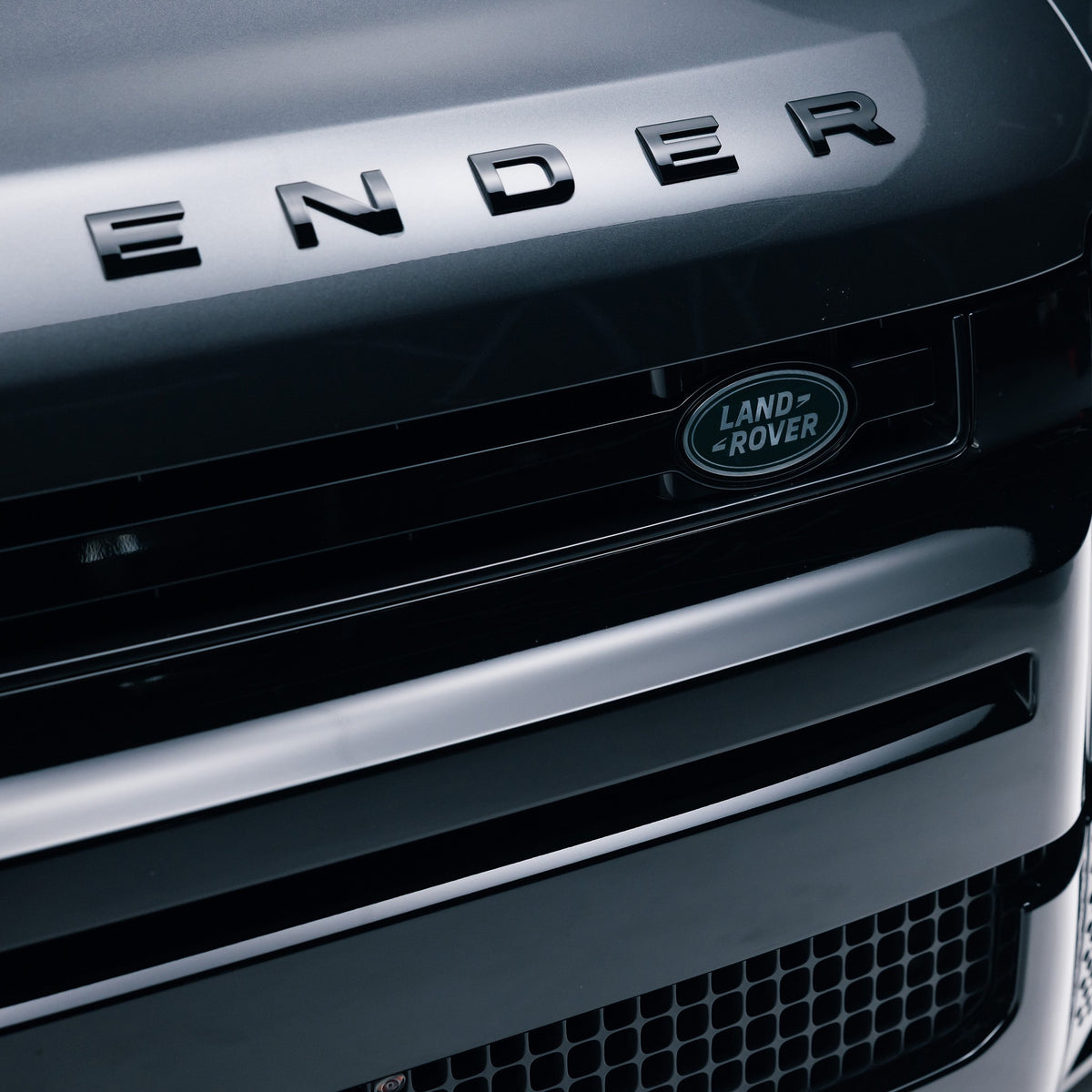 Gloss Black front grille trim fitted to a Land Rover Defender 110, close up