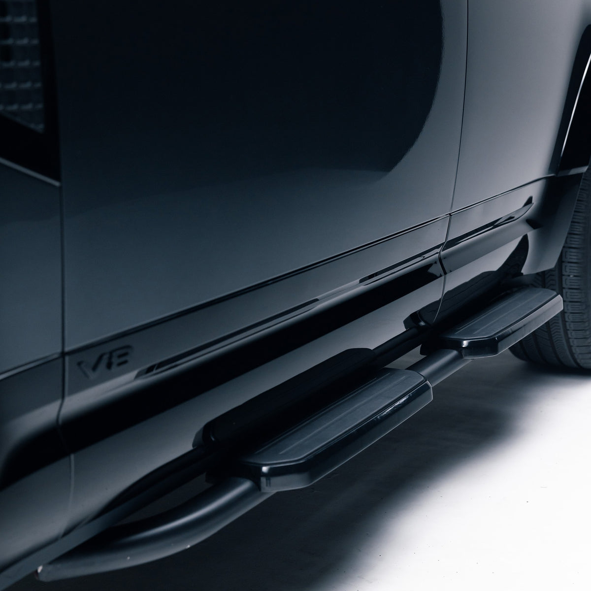 Gloss Black lower door moulding with V8 badge on a Land Rover Defender 110