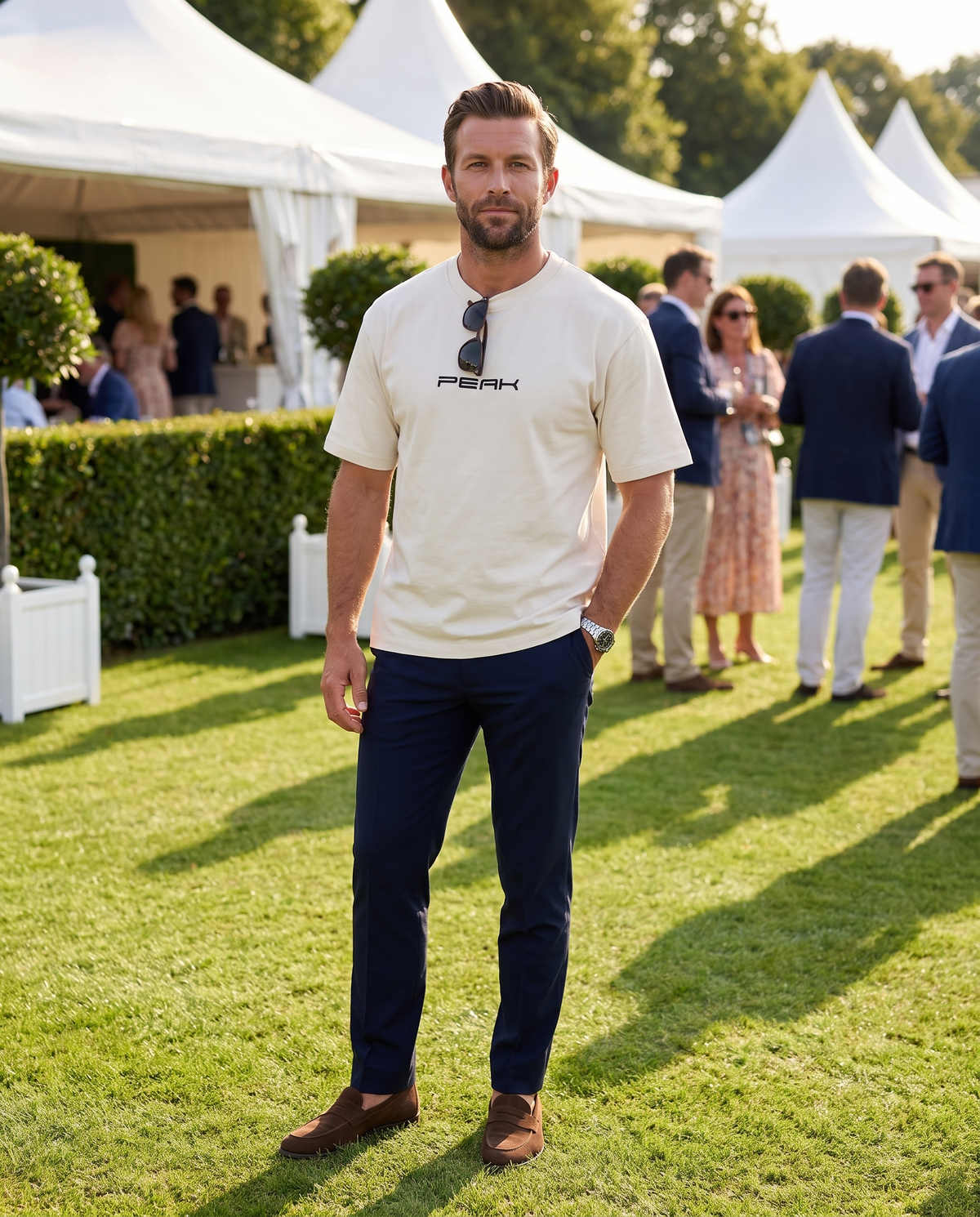 PEAK Heavy Tee in Ecru, worn on the lawn at a grand prix hospitality garden