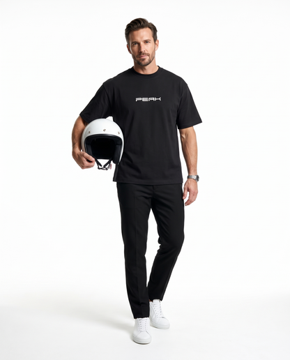 PEAK Heavy Tee in Black, worn with a white racing helmet in hand