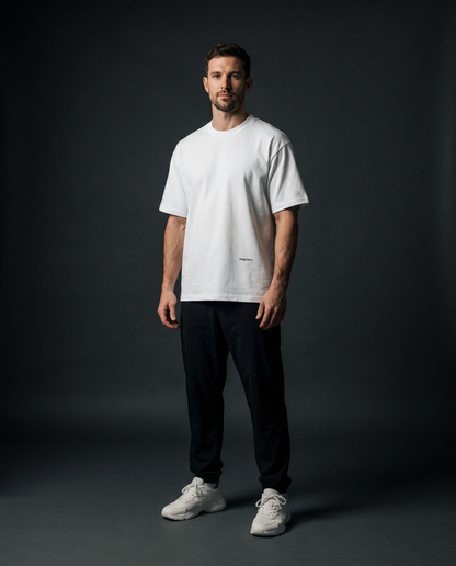 PEAK Hem Tee in White, worn in a dark studio