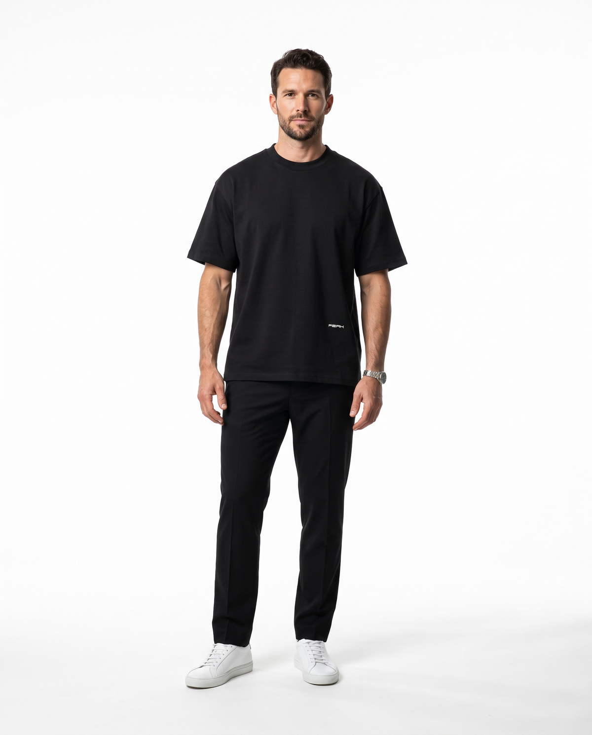 PEAK Hem Tee in Black with a small wordmark low on the front, worn by a man