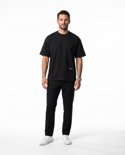 PEAK Hem Tee in Black with a small wordmark low on the front, worn by a man