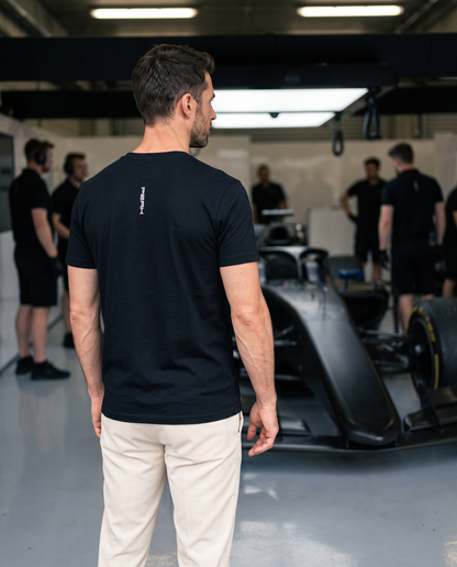 PEAK Tee, Chest & Spine Print, back view of the vertical spine wordmark in a race team garage