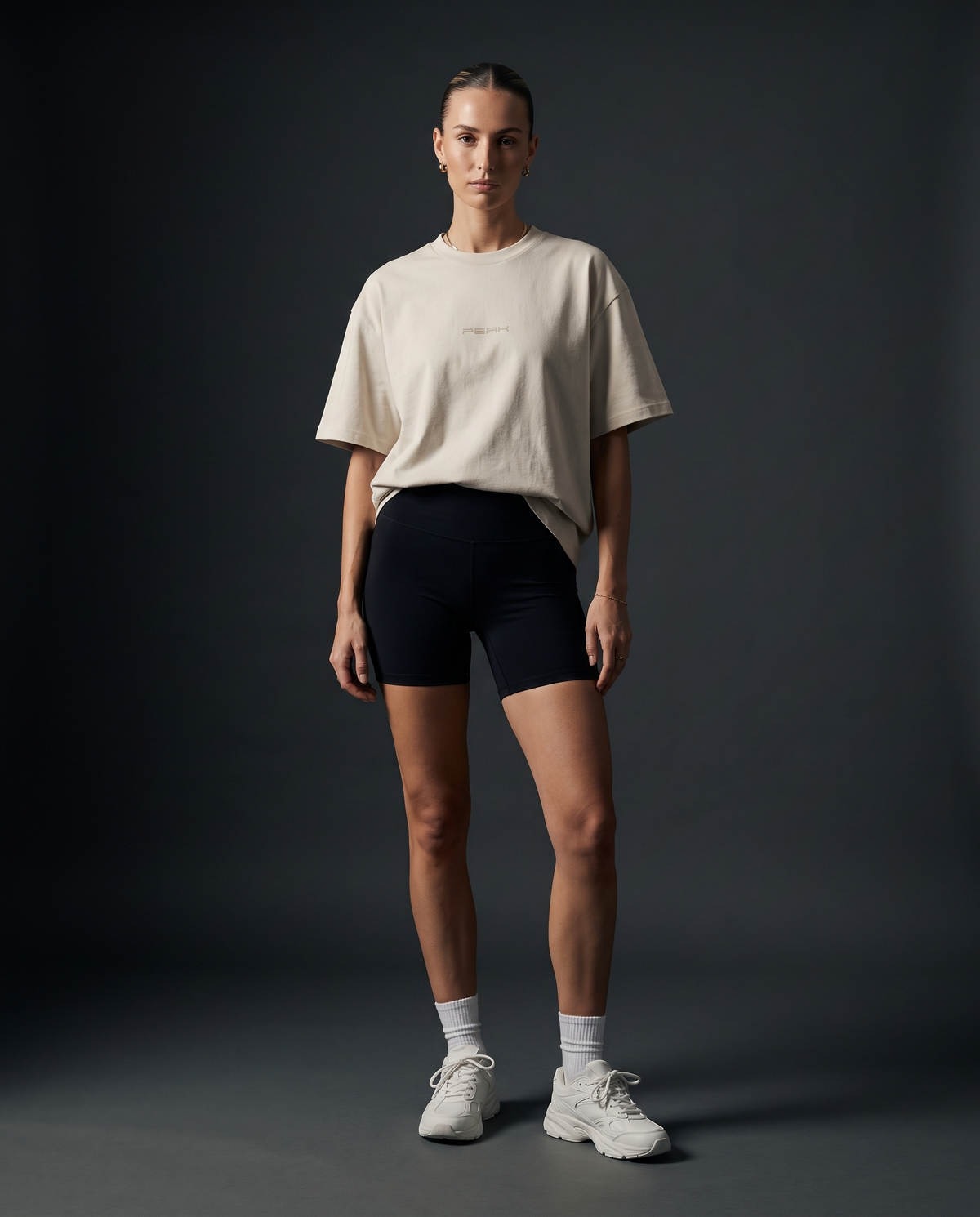 PEAK Tonal Tee in Ecru with a sand chest wordmark, worn by a woman