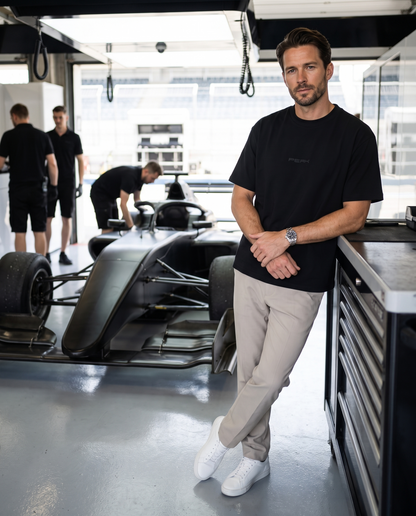 PEAK Tonal Tee in Black, worn in a race team pit garage