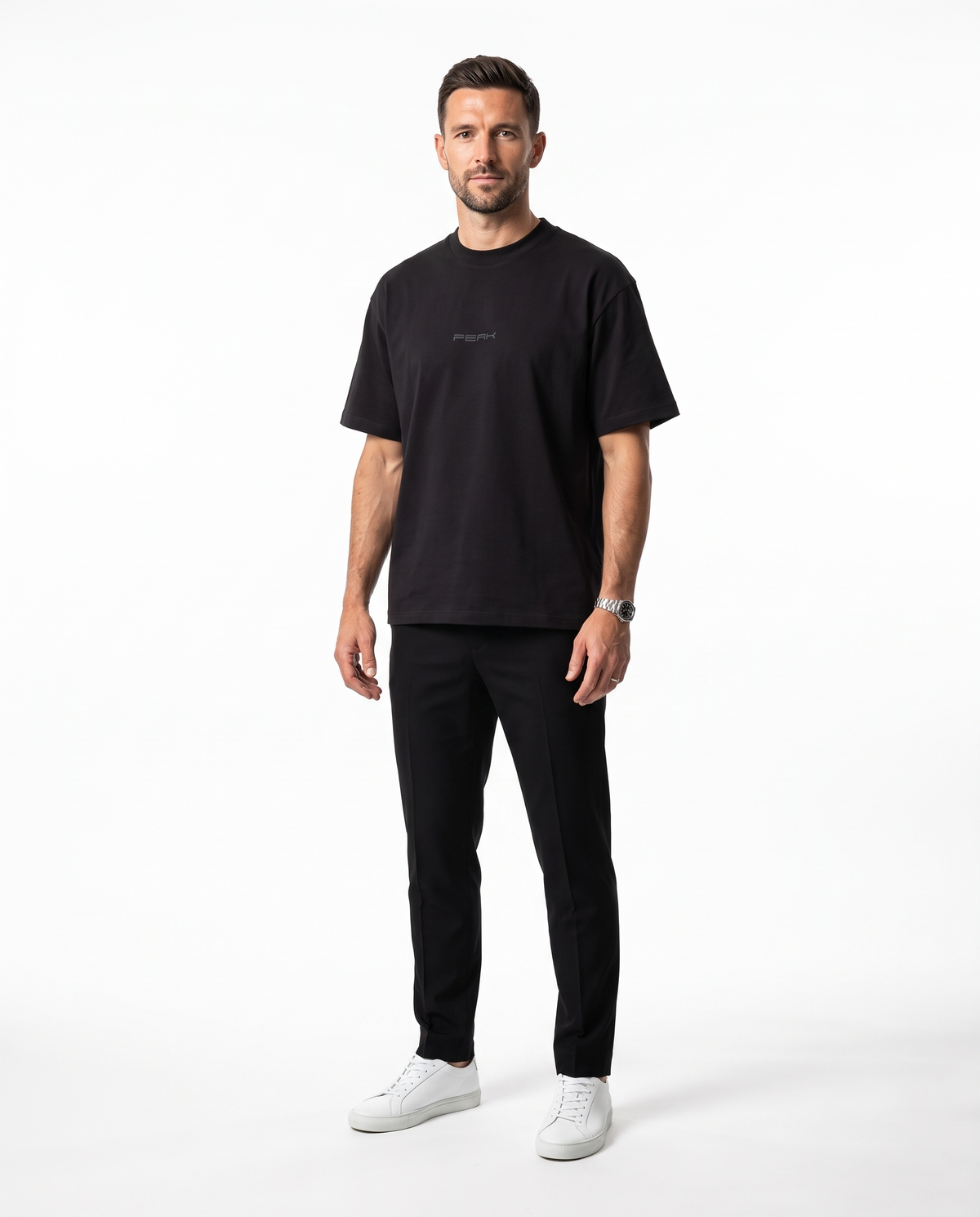 PEAK Tonal Tee in Black with a charcoal chest wordmark, worn by a man