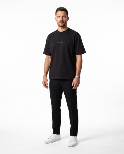 PEAK Tonal Tee in Black with a charcoal chest wordmark, worn by a man