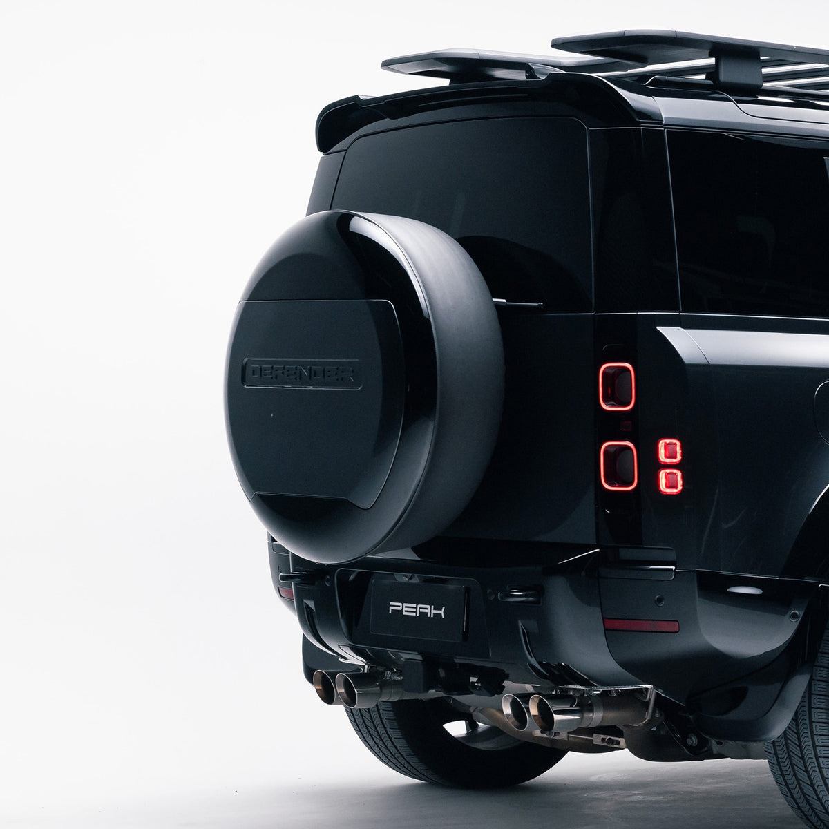 Land Rover Defender 110 rear three-quarter view with Gloss Black spare wheel cover