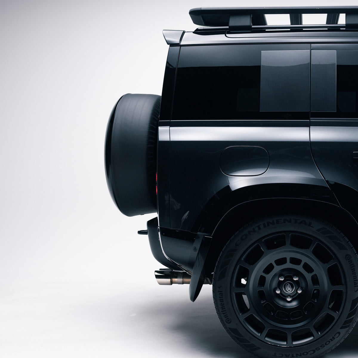 Side profile of a Gloss Black spare wheel cover on a Land Rover Defender 110